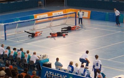 3 spelers liggen op de grond om de bal tegen te houden